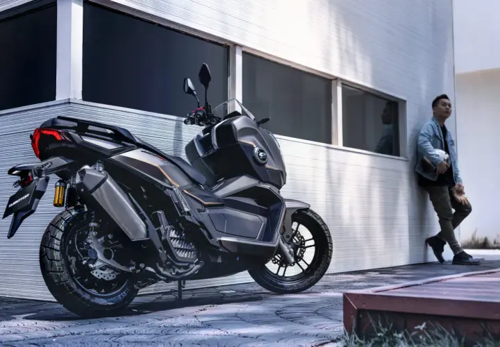 Un hombre apoya su casco en una moto moderna, lista para la aventura. La ficha técnica de esta moto promete potencia y estilo.