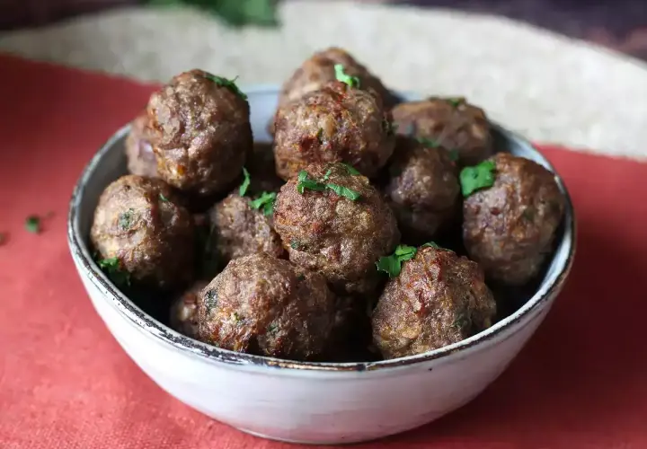 Succulente polpette in friggitrice ad aria, dorate e profumate, guarnite con prezzemolo fresco.