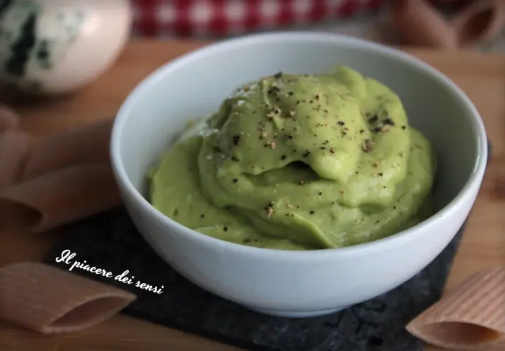 Una cremosa salsa avocado, cosparsa di pepe nero, in una ciotola bianca. Perfetta per accompagnare pasta o come dip.