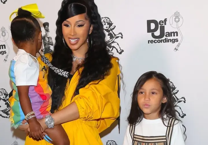 Cardi B z dziećmi na ściance Def Jam. Jedno dziecko w kolorowej stylizacji, drugie obok.
