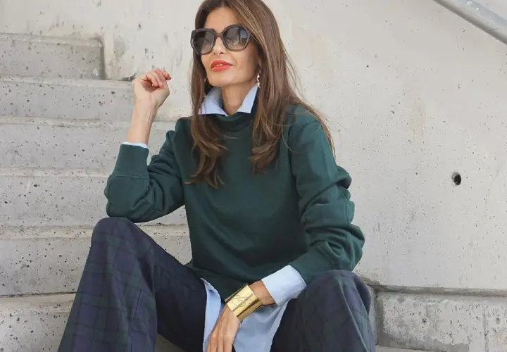 Elegancka kobieta po 50-tce w zielonym swetrze i kratkowych spodniach. Stylowe moda po 50-tce stylizacje.