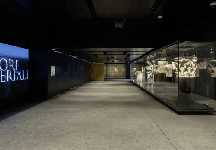 Corridoio moderno con reperti antichi esposti in teche di vetro, un omaggio ai Fori Imperiali, vicino alla metro C Roma Colosseo.