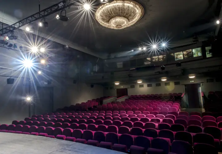 Puste fioletowe fotele w **Teatrze Studio im. Stanisława Ignacego Witkiewicza** czekają na widzów. Reflektory oświetlają scenę.