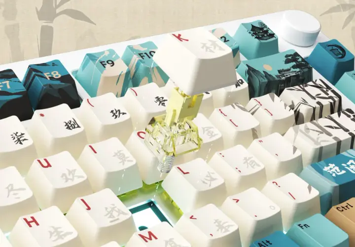 Nahaufnahme einer weißen Tastatur mit chinesischen Schriftzeichen und Bambusmotiven. Eine Taste mit einem gelben Schalter ist sichtbar, was auf ein rapid trigger keyboard hindeutet.