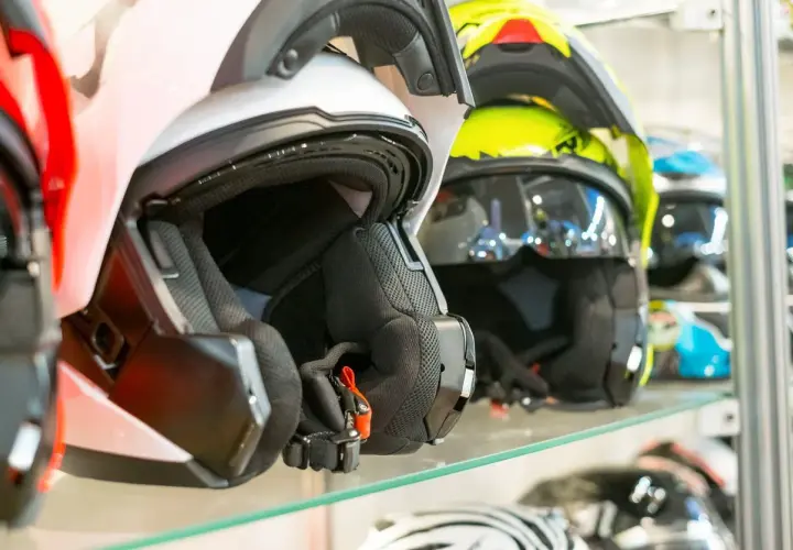 Cascos de moto de varios colores, incluyendo un casco no integral blanco en primer plano, listos para la aventura.