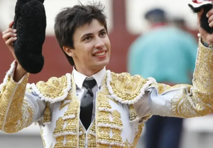 Francisco José Espada, torero, sonríe con su traje de luces dorado y blanco, alzando la montera y el capote.