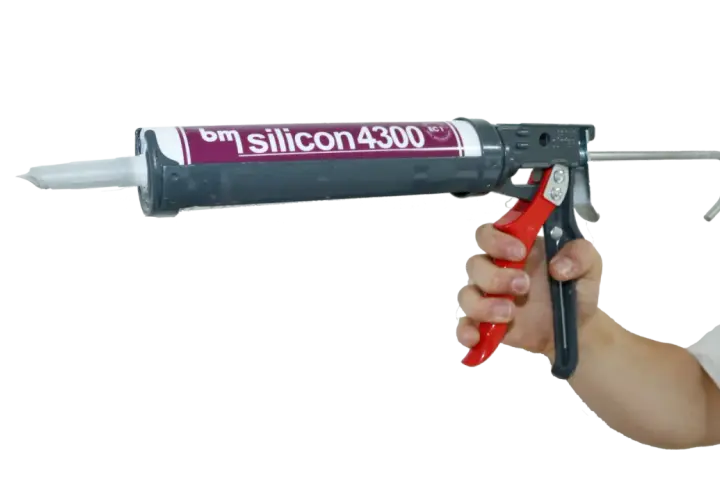 Hand hält eine Kartuschenpistole mit "bm silicon 4300" für das acryl dichtmasse entfernen.
