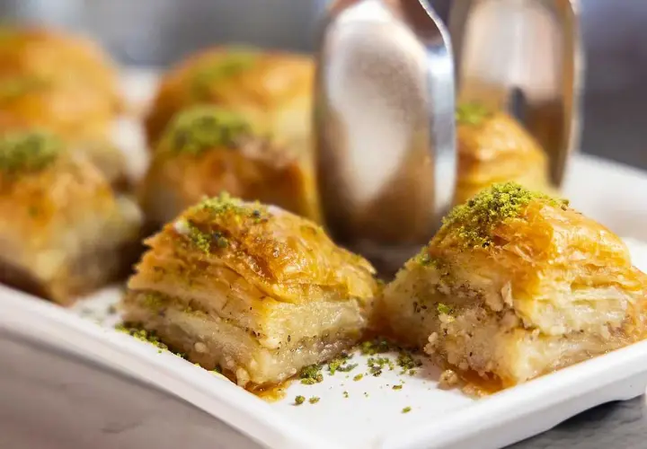 Krispiga bitar av baklava, strösslade med gröna pistagenötter. Perfekt för ett enkelt baklava recept.