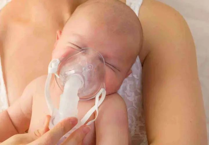 Bambino con maschera per inalazione, un aiuto per la tosse.