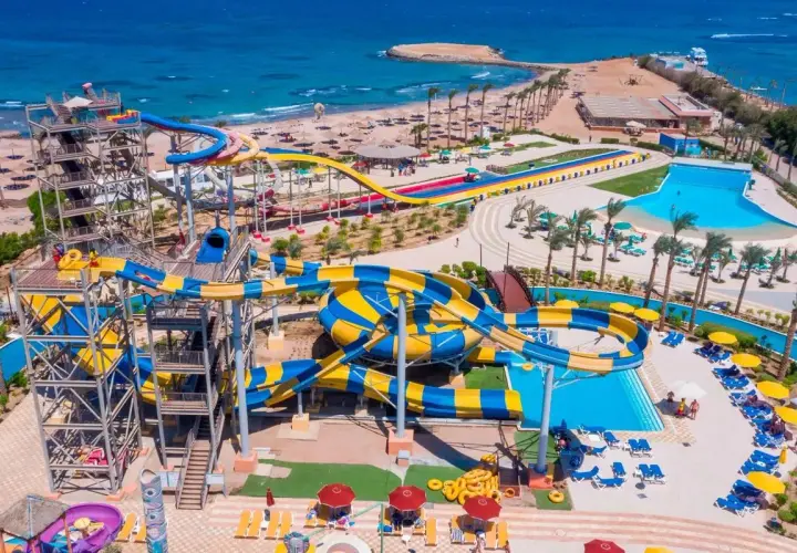Wodne zjeżdżalnie w Blend Club Aqua Resort kuszą kolorami i zabawą. Widać plażę i turkusowe morze.