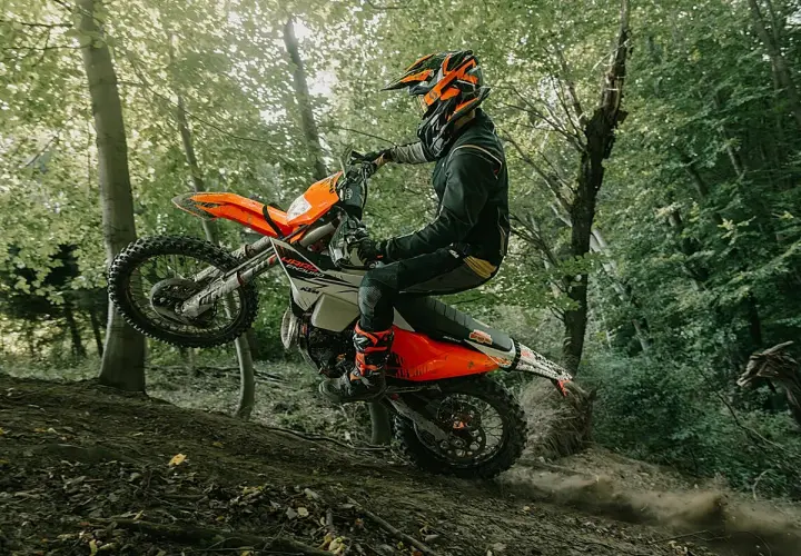 Motociclista en KTM salta en un sendero boscoso. ¡Las últimas ktm noticias sobre enduro!
