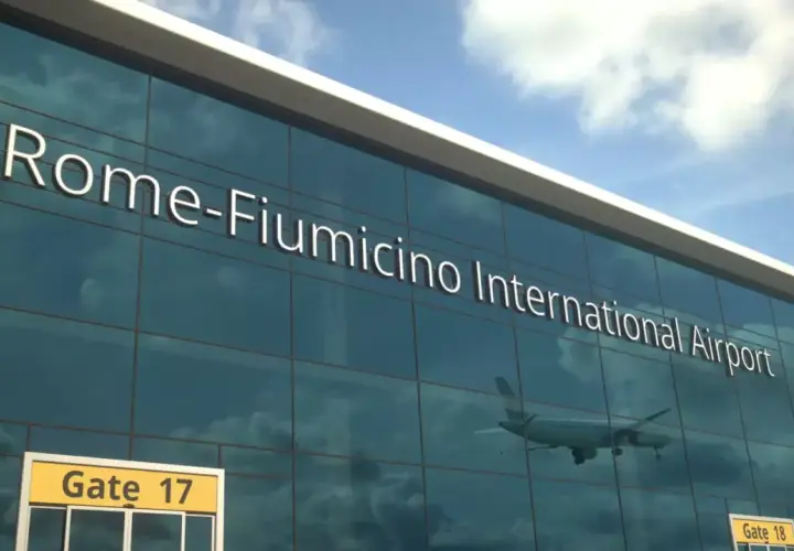 Szklana fasada lotniska Rome-Fiumicino International Airport, z odbijającym się samolotem i tabliczką "Gate 17".