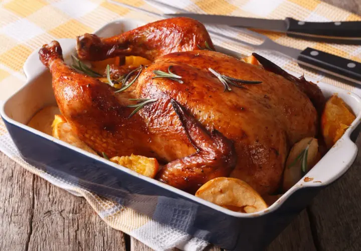 Un délicieux filet de poulet au barbecue, doré et juteux, servi avec des quartiers d'orange et des pommes de terre rôties.