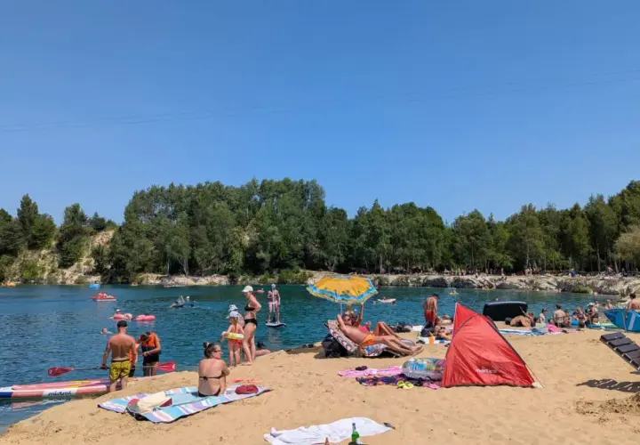 Słoneczny dzień nad zalewem Balaton Trzebinia. Ludzie odpoczywają na plaży, pływają i relaksują się w wodzie.