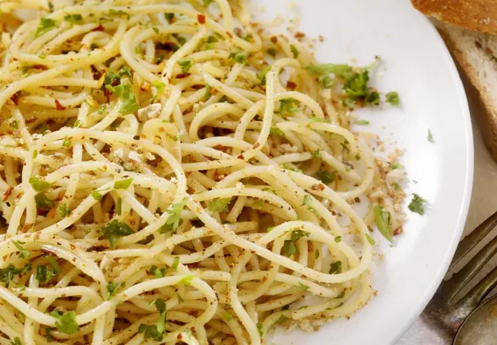Un piatto di spaghetti alla carrettiera, conditi con aglio, olio, peperoncino e prezzemolo fresco, con una spolverata di pangrattato tostato.