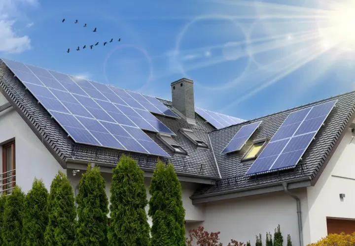 Instalacja fotowoltaiczna 6 kW cena z montażem na dachu domu. Słoneczny dzień, ptaki na niebie.