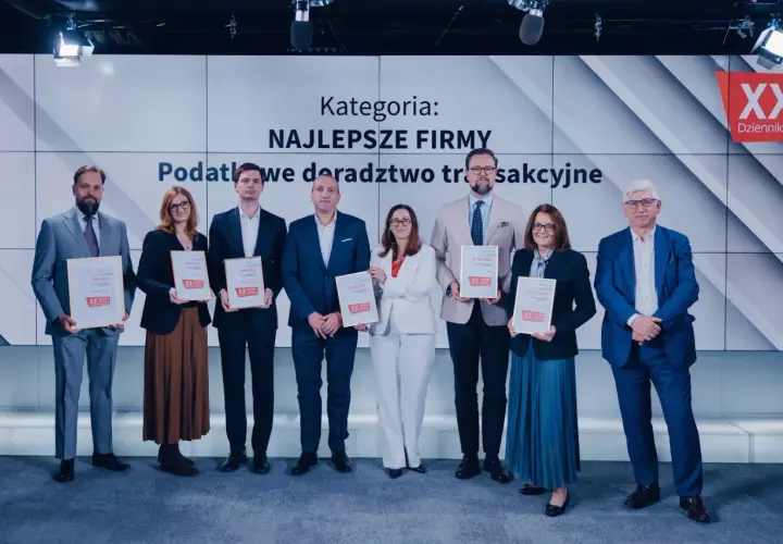Grupa osób odbiera nagrody na tle ekranu z napisem "Kategoria: Najlepsze Firmy".