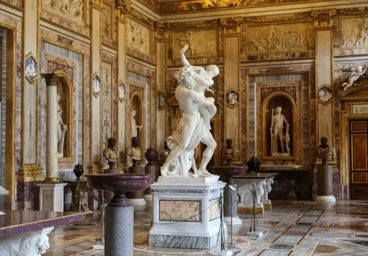 Salle somptueuse de la **Gallerie Borghese** ornée de sculptures antiques, dont le groupe du Bernin, et de riches décorations murales.