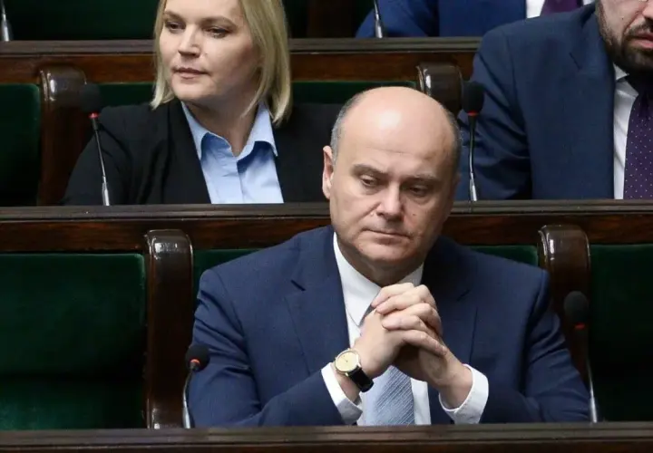 Poseł z zamyśloną miną, w garniturze, siedzi w ławach sejmowych. Czy to zapowiedź bankructwa Polski?