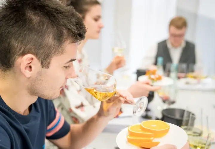 Teilnehmer einer WSET Kurse verkosten Wein und Orangen.