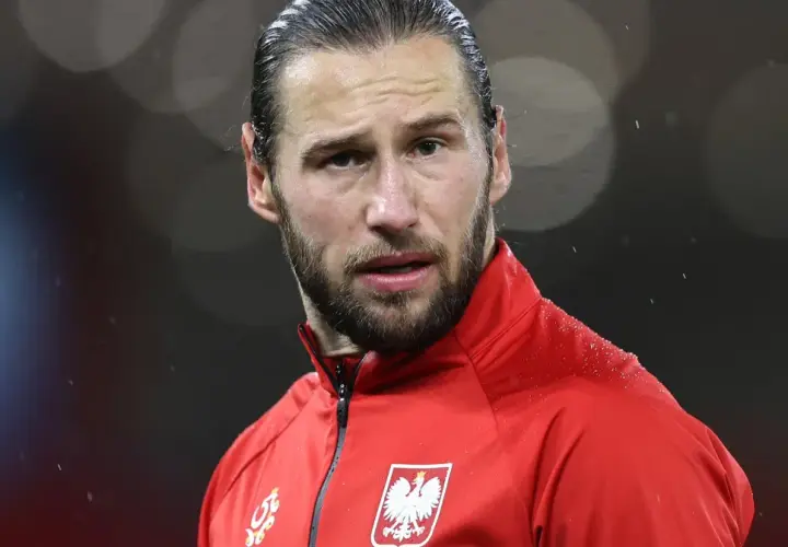 Piłkarz w czerwonej bluzie z orłem na piersi, w deszczu. Krychowiak gdzie gra? Na boisku, w barwach narodowych.