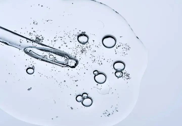 Kropla serum z pipetki, bąbelki unoszące się w żelu. Czy peptydy można łączyć z witaminą C? To pytanie nurtuje miłośników pielęgnacji.