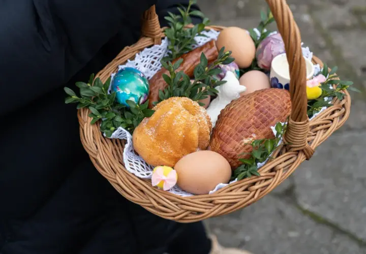Wielkanocny koszyczek z jajkami, babką, kiełbasą i wędliną.