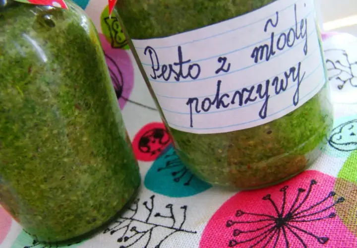 Dwa słoiki z zielonym pesto z pokrzywy, jedno z etykietą "Pesto z młodej pokrzywy".