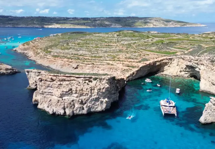 Malta ciekawostki: Błękitna Laguna na Comino, z jaskiniami, łodziami i krystalicznie czystą wodą.