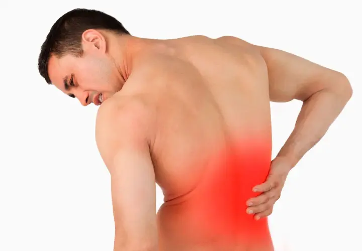 Hombre con dolor lumbar izquierdo, con la mano en la zona afectada y expresión de sufrimiento.