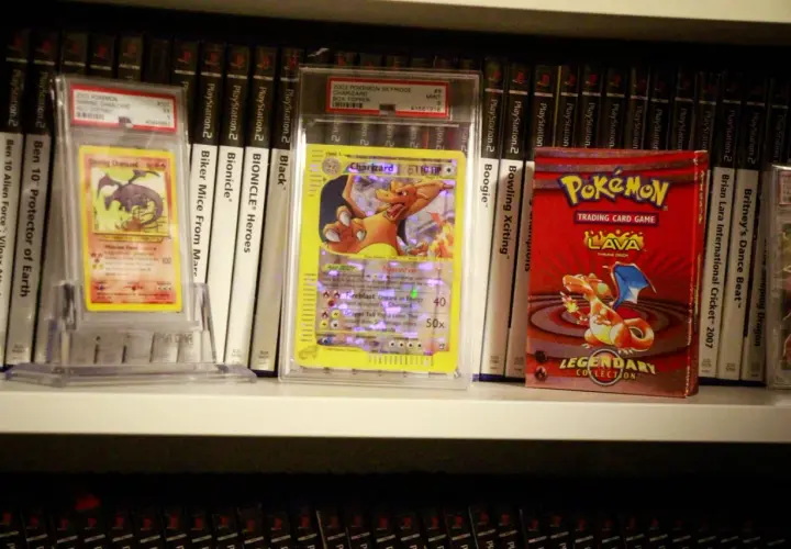 Pokémon-kort och en Pokémon-kortlek på en hylla, bland andra samlarobjekt.