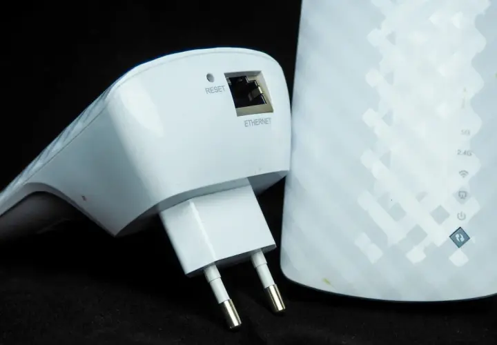 Dwa białe urządzenia sieciowe: wzmacniacz Wi-Fi z wtyczką i portem Ethernet oraz większy repeater z oznaczeniami 5G, 2.4G i ikonami.