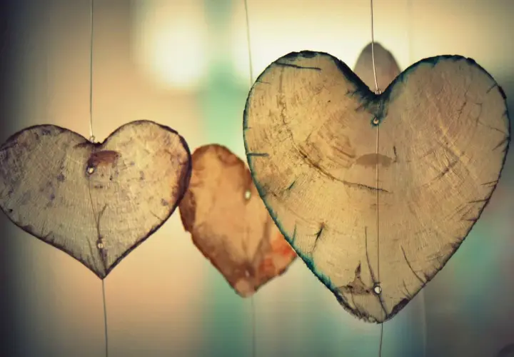 Holzherzen hängen an dünnen Fäden. Sie erinnern an die wahre agape bedeutung: bedingungslose Liebe, die wächst und Bestand hat.