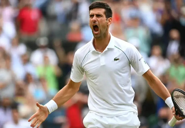 Emocjonalny tenisista Djokovic krzyczy z kortu, świętując zwycięstwo.