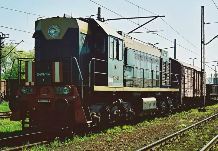 Lokomotywa SM48-104 z wagonami towarowymi na torach.