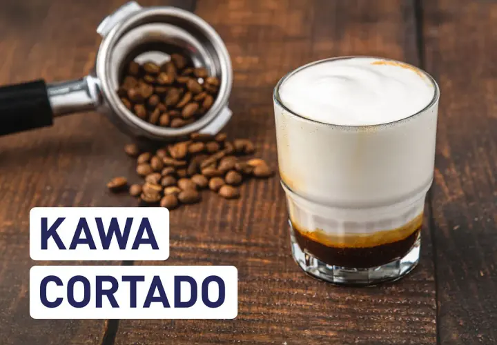 Kawa cortado z mleczną pianką, obok portafiltr z ziarnami kawy. Idealna na poranek.