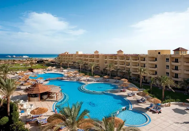 Relaks przy basenie w Amwaj Beach Club Resort. Palmy, leżaki i błękitna woda zapraszają do wypoczynku.