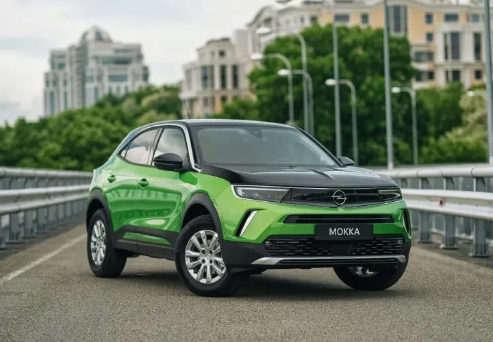 Zielony Opel Mokka na moście, z widocznymi felgami i oponami. Idealny rozmiar opon dla tego miejskiego SUV-a.