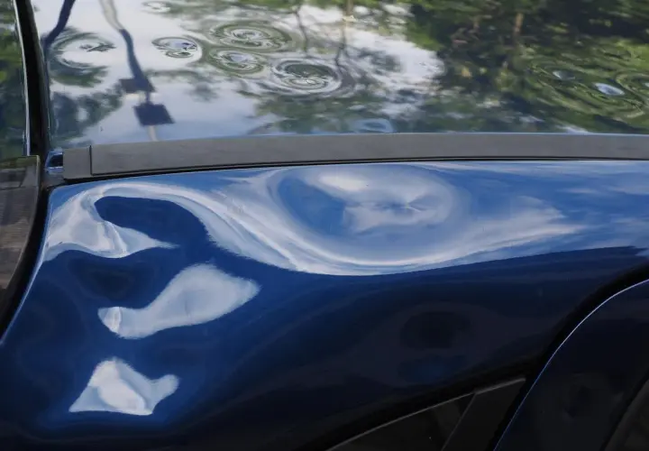 La mia auto blu parcheggiata è stata tamponata. Ci sono diverse ammaccature evidenti sulla carrozzeria, tra cui una grande e profonda. Ho la targa.