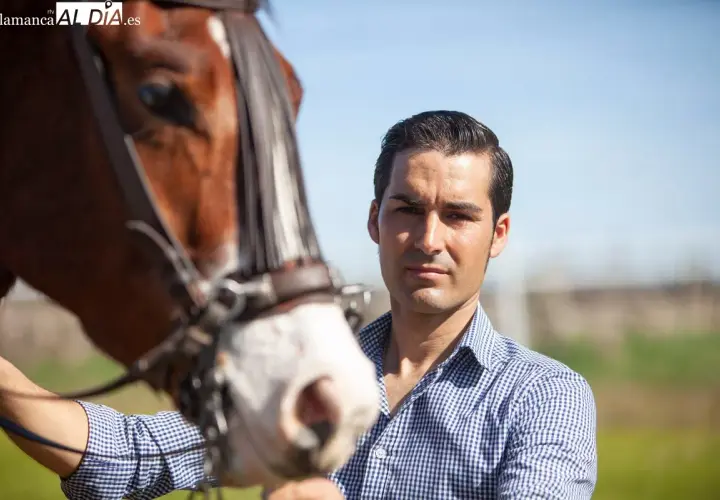 Alberto Sandoval, picador, posa junto a un caballo castaño con brida.