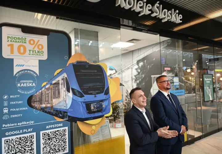 Promocja Kolei Śląskich z rabatem 10% w aplikacji. Na ekranie smartfona widok nowoczesnego pociągu.