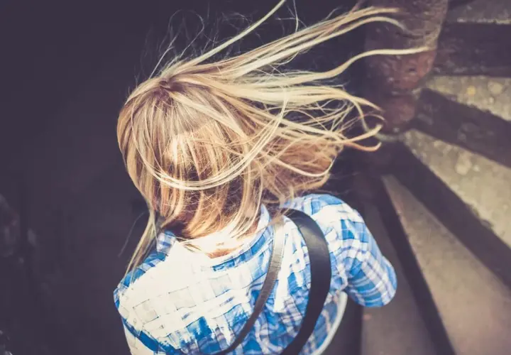 Rubia con pelo al viento, buscando cómo aclarar el pelo naturalmente.