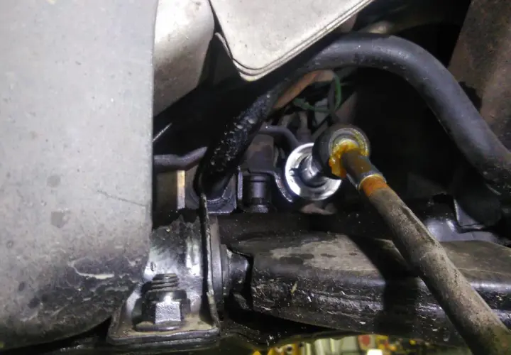 Zbliżenie na element układu kierowniczego samochodu, widoczny przegub i metalowe elementy.
