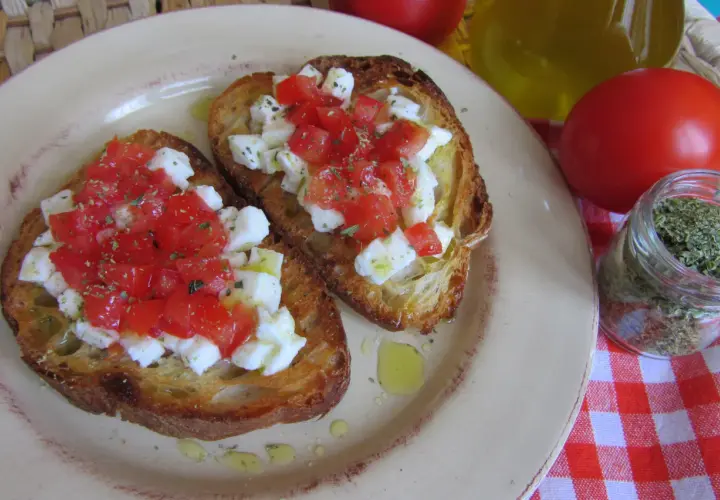 Bruschetta z pomidorami i mozzarellą: chrupiące grzanki z serem, pomidorami i ziołami. Idealny przepis na szybką przekąskę.