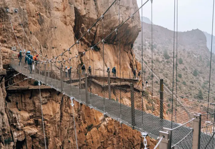 Spacer po Caminito del Rey z dzieckiem. Wąska ścieżka zawieszona nad przepaścią, otoczona skalnymi ścianami.