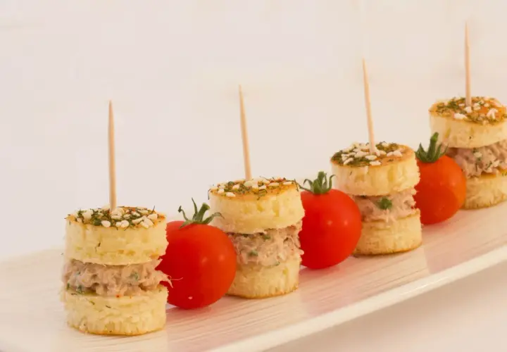 Petits pains garnis de thon, parsemés d'herbes et de sésame, accompagnés de tomates cerises. Une délicieuse brochette apéro.