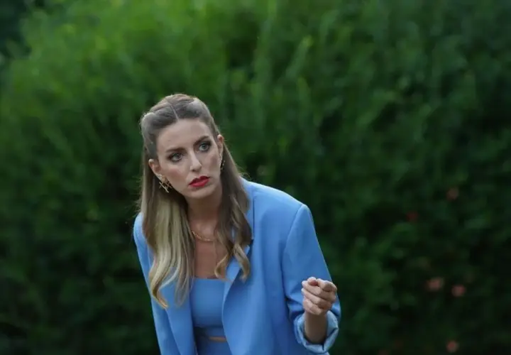 Eda z "Zapukaj do moich drzwi" w błękitnym żakiecie, z burzą blond włosów i wyrazistym makijażem, spogląda z uwagą w bok.