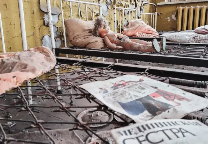 Opuszczone łóżka w Czarnobylu, z lalką i gazetą "Медсестра", przypominają o ofiarach tragedii.