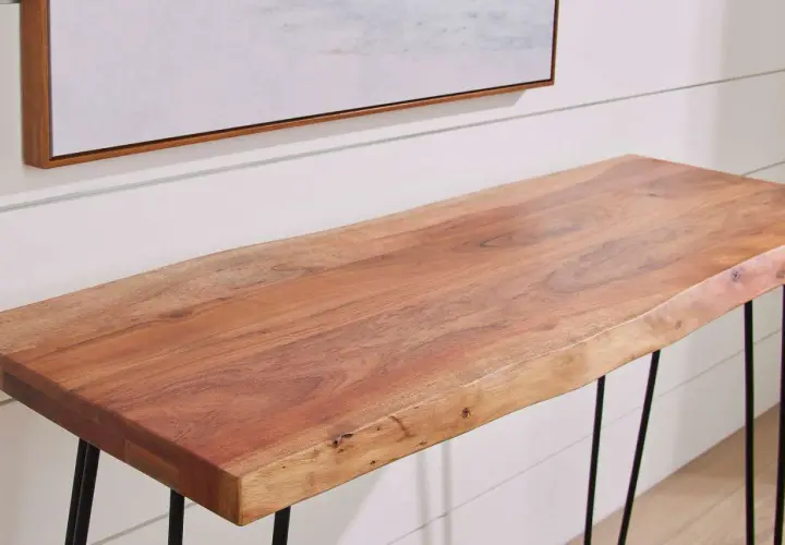 A live-edge acacia wood console table with black hairpin legs, showcasing the natural grain and warmth of the wood.