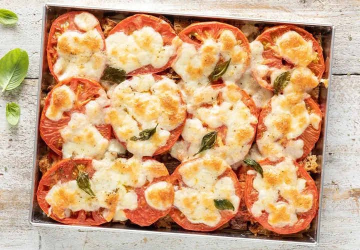Pomodori al forno con mozzarella filante e basilico. Un'idea gustosa per cosa mangiare stasera, semplice e veloce da preparare.